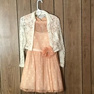 Girls peach lace dress with flower in front and a white lace shawl.